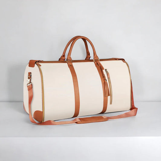 White duffel bag with brown leather straps on a light gray background