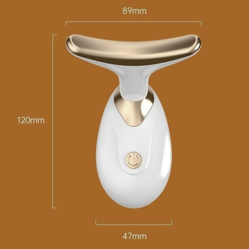 White and gold facial massager with dimensions on a brown background